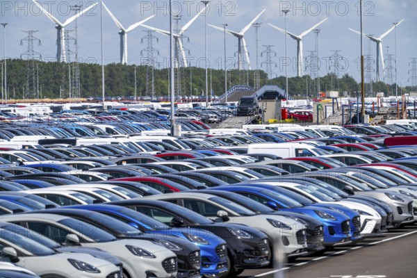 Storage area for new cars in the port of Vlissingen-Oost, vehicles are temporarily stored on over 100 hectares to ship them from Europe to the United Kingdom, Ford cars, others such as models from the Chinese car manufacturer BYD are delivered from here in Europe, wind farm, Netherlands