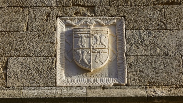 A coat of arms engraved in a stone wall with detailed historical patterns and text, Knights Street, Rhodes Old Town, Rhodes Town, Rhodes, Dodecanese, Greek Islands, Greece, Europe