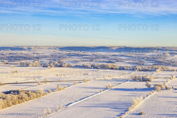 Aerial view at a rural landscape with snow and frost on the fields a cold winter day, Sweden, Europe