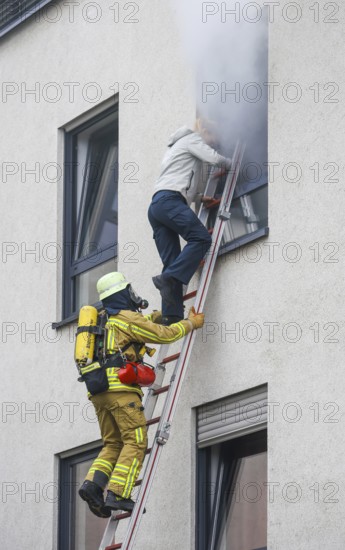 Duisburg, North Rhine-Westphalia, Germany, firefighting exercise, people are rescued from a burning flat. Press event: Federal Chancellor Olaf Scholz visits fire engine 530 of the Duisburg volunteer fire brigade at fire and rescue station 5 in Homberg. Together with a firefighting unit of the professional fire brigade, the firefighting school is also housed there, Europe