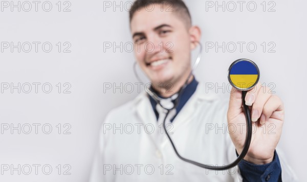 Happy doctor showing stethoscope with Ukraine flag. Ukraine National Healthcare concept