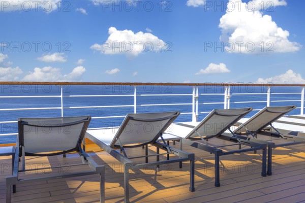 Cruise ship deck and lounge chairs overlooking beautiful ocean on a cruise vacation in Caribbean