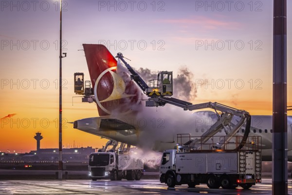 Frost at the airport, a Turkish Airlines aircraft is de-iced in front of sunrise. Airbus A321-231, Fraport, Frankfurt am Main, Hesse, Germany, Europe