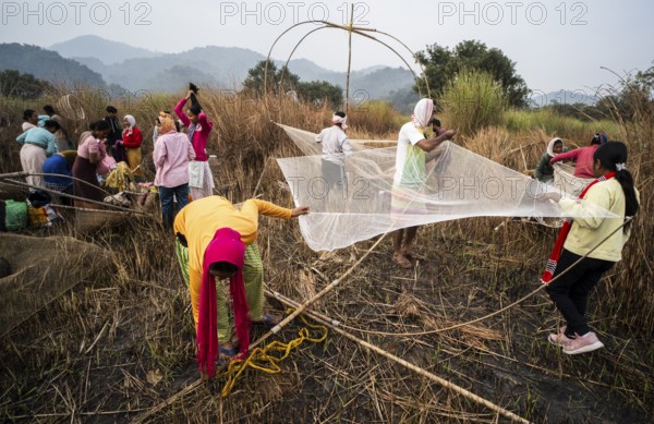 Villagers participate in a community fishing event on the occasion of the Bhogali Bihu festival at Panbari village in Assam on 13 January 2025. Magh Bihu, also known as Bhogali Bihu, is one of the most vibrant festivals celebrated in Assam and other parts of Northeast India