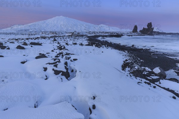 Rocks, lava field and surf at the coast, evening light, sun, snow, winter, Arnarstapi, Snaefellsjökull, Snaefellsnes, Vesturland, Iceland, Europe