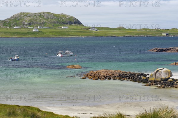 Some boats on the sea in front of a rocky coast, island with houses, view of Iona, Port of Fionnphort, Isle of Mull, Inner Hebrides, Scotland, Great Britain