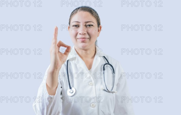 Beautiful female doctor gesturing approval isolated. Smiling female doctor approving and recommending isolated