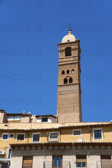 High historical tower in front of a blue sky with residential buildings in the foreground, church, Iglesia de Santa María Magdalena, Tarazona, Zaragoza, Aragon, Spain, Europe