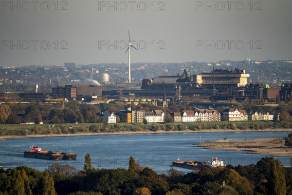 Cargo ships on the Rhine near Duisburg, houses on Deichstrasse, industrial backdrop of the ArcelorMittal Hochfeld GmbH steel wire plant, North Rhine-Westphalia, Germany, Europe