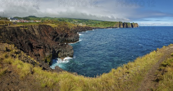 Panorama of a rocky coastline with a view of the vast blue sea and steep cliffs, Capelas, Sao Miguel Island, Azores, Portugal, Europe