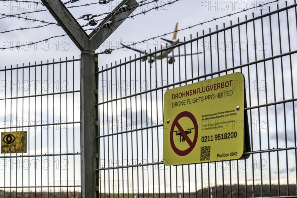 Düsseldorf International Airport, security fence at the border of the airport, runway, notice on the drone flight ban at airports, aircraft approaching, North Rhine-Westphalia, Germany, Europe