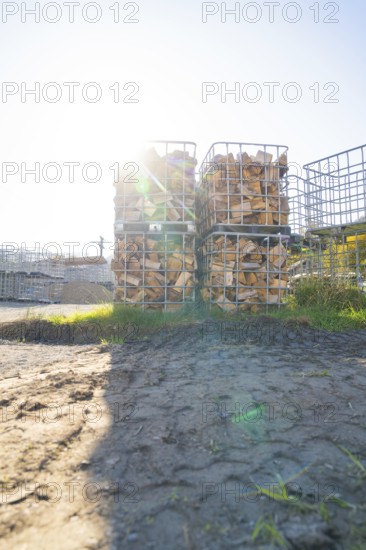 Stacked pieces of wood in metal frames in a meadow with sunshine and shade, refugee accommodation Beermiß, Calmbach, Black Forest, Germany, Europe