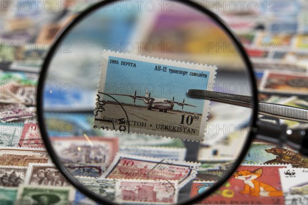 Stamp collection, collecting, postage stamps, postage stamps from different countries, magnifying glass, stamp with aeroplane from Uzbekistan, Antonov An-12