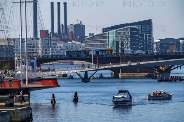 View over the harbour, in front left the Cirkelbroen bridge, the Lille Langebro cycle and footpath bridge, behind it the Langebro road bridge, in the background skyline at Sydhavnen, chimneys of the H.C. Ørstedsværket thermal power station, Copenhagen, Denmark, Europe