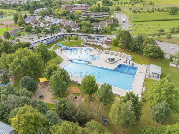 Aerial view of an outdoor swimming pool with several pools, slides and surrounding trees in a green landscape, outdoor pool Calw, Black Forest, Germany, Europe