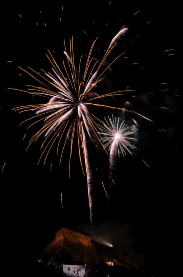 Fireworks light up the night sky above a building with glowing sparks, New Year's Eve, Stallbastei, Schlossberg, Graz, Styria