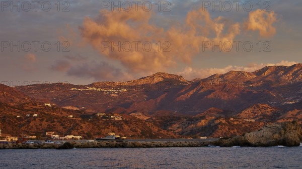 Atmospheric coastal landscape at sunrise, with dramatic clouds and mountain backdrop, Pigadia, town and harbour, Pigadia Bay, main town, Karpathos, Dodecanese, Greek Islands, Greece, Europe