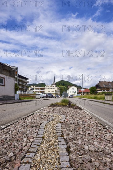 Traffic island, general architecture, Church of St Ulrich, hilly landscape with coniferous forest, blue sky with nimbostratus clouds and cumulus clouds, frog perspective, street in the village, Nordrach, Black Forest, Ortenaukreis, Baden-Württemberg, Germany, Europe