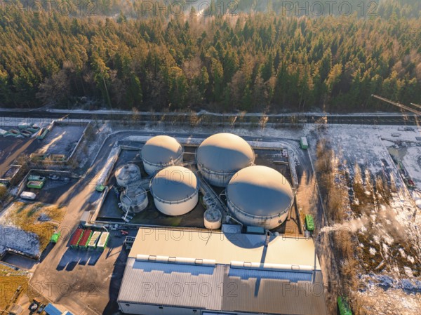 Aerial view of an industrial tank farm surrounded by snow-covered forest, Neubulach, Black Forest, Germany, Europe