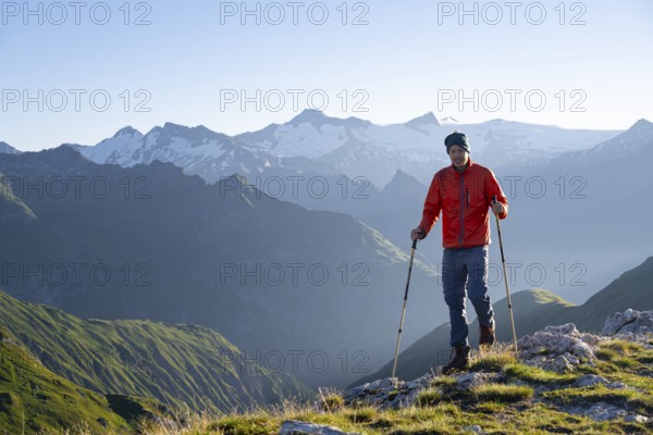 Hiker enjoying the mountain panorama in the morning, Venediger group, behind Dreiherrenkopf, Simonysitze and Großer Geiger, Hohen Tauern, Austria, Europe