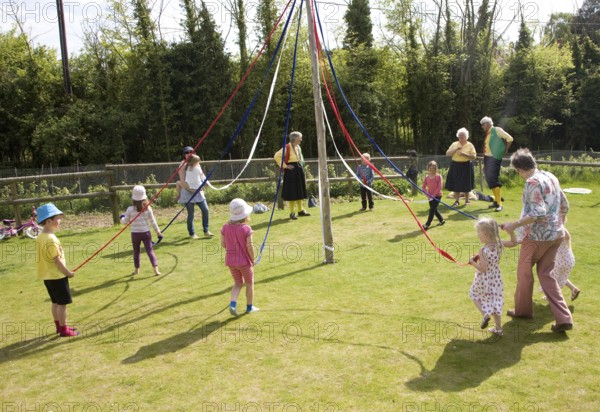 Children dance around a maypole at an English country festival, Shottisham, Suffolk, England, United Kingdom, Europe