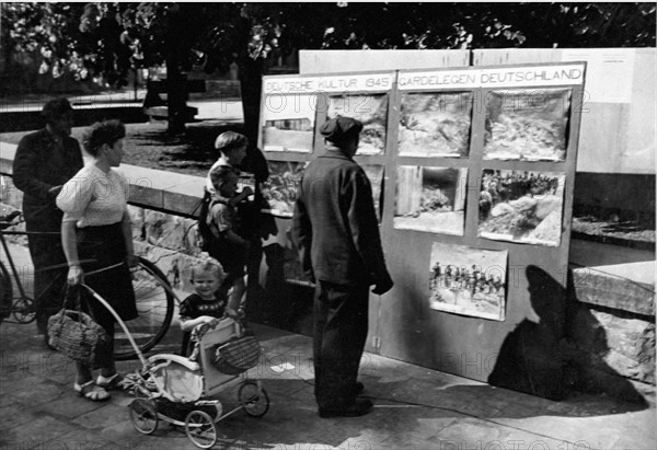 A Beckum, des allemands regardent les photos des camps (11 mai 1945)