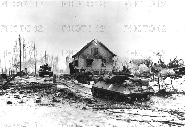 Des chars d'assaut français traversent la ville de Bettenhoffen ravagée par la guerre (France, janvier 1945).