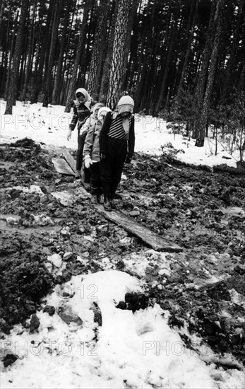 Children walking over a ground devastated by military exercises