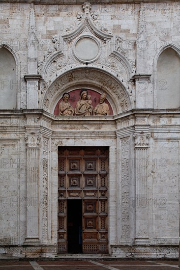 Montepulciano, church of St. Augustine: detail of the portal with the lunette with the terracotta relief of the “Madonna and Saints John the Baptist and Augustine”, by, Michelozzo di Bartolomeo, 1427.
Founded in 1285, the church was completely renovated in the 15th century, with the intervention of Michelozzo di Bartolomeo for the construction of the lower part of the facade, punctuated by fluted pilasters, surmounted by niches that frame the portal.
Chiesa di Sant'Agostino, Montepulciano (SI), Toscana - Tuscany, Italia - Italy