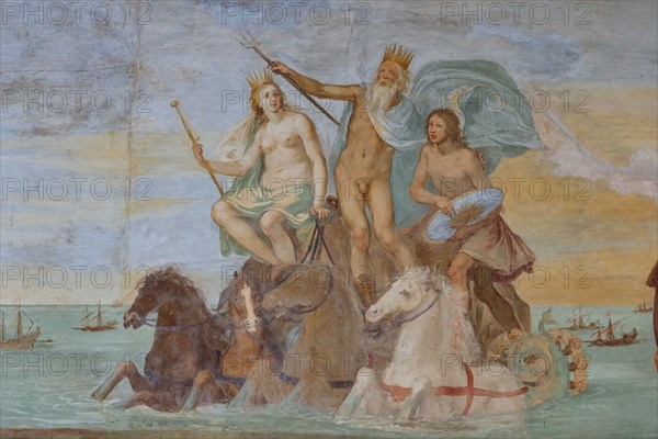 Medici Villa La Petraia, courtyard:“Dominance of Tuscany over the sea”, fresco from the cycle of the Fasti Medicei by Volterrano (Baldassarre Franceschini), 1636-1647.
The scene is set in Livorno, the Medici port and ideal city refounded by Francesco I de' Medici and his brother Ferdinand I, in the shadow of the monument of the Four Moors, with the statue of Ferdinand crowned by two winged victories. In the centre, in the background, Neptune's chariot proceeds, with Galatea and Perseus (holding Medusa's shield), to which the sea god points the statue. They sail among a large group of galleys of the Order of Saint Stephen.
On the right, in front of a cloth held up by putti in the face and under a personification of Fame, we see the allegories of Tuscany (with the crossed shield), of the Grand Duchy (with crown, scepter and mantle with the crest of the Order) and of Livorno, with the castle coat of arms.
Detail.
Villa medicea La Petraia, Firenze (FI) - Florence, Toscana - Tuscany, It...