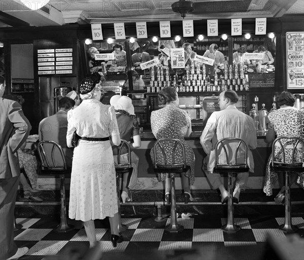 Rear view of lunchtime crowd at noon, People's Drugstore, G Street N.W., Washington, D.C., USA, Marjory Collins, U.S. Office of War Information, July 1942War Information