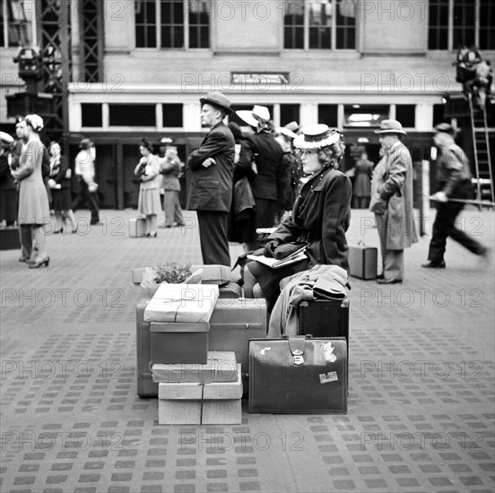 Woman sitting on luggage while waiting for train, Pennsylvania Station, New York City, New York, USA, Gordon Parks, U.S. Office of War Information, June 1943