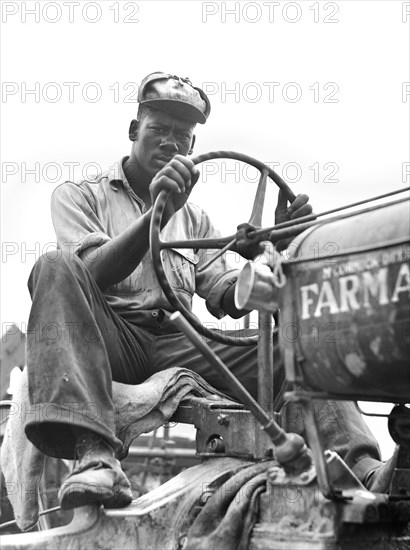 Driver of combine threshing oats on La Delta Project, Thomastown, Louisiana, USA, Marion Post Wolcott, U.S. Farm Security Administration, June 1940