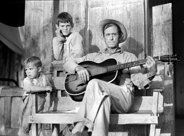 Father playing acoustic guitar with two sons, Natchitoches, Louisiana, USA, Marion Post Wolcott, U.S. Farm Security Administration, June 1940