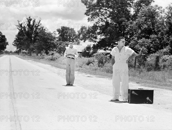 Two young men waiting for a ride on rural road, Natchitoches, Louisiana, USA, Marion Post Wolcott, U.S. Farm Security Administration, June 1940