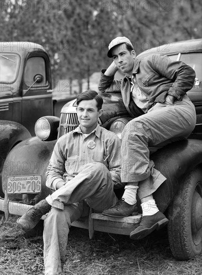 Two construction workers from Monroe, Louisiana sitting on car in front of their shacks before leaving for evening shift, Camp Livingston, Alexandria, Louisiana, Marion Post Wolcott, U.S. Farm Security Administration, December 1940