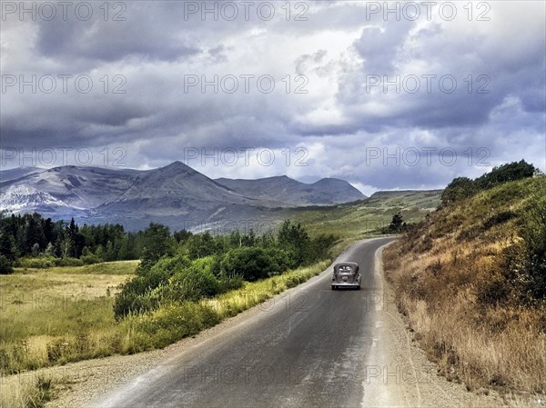 Car traveling on rural road through Glacier National Park, Montana, USA, Marion Post Wolcott, U.S. Farm Security Administration, August 1941