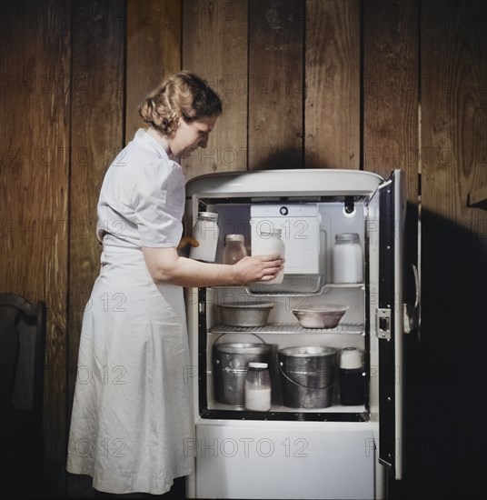 Mrs. Pleas Rodden, FSA (Farm Security Administration) rural rehabilitation borrowers, putting fresh milk from their own cow in their Frigidaire, West Carroll Parish, Louisiana, USA, Marion Post Wolcott, U.S. Farm Security Administration, June 1940