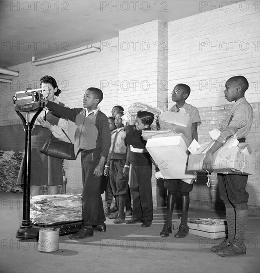 Students lined up to weigh collected scrap paper at school during Scrap Salvage Campaign, Victory Program, Washington, D.C., USA, Marjory Collins, U.S. Office of War Information, March 1942