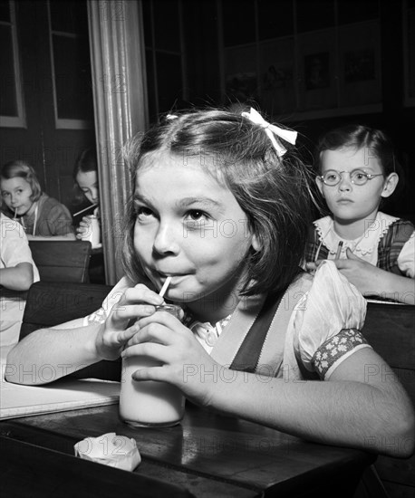 Young girl drinking glass of milk in classroom, New York City, New York, USA, Marjory Collins, U.S. Office of War Information, October 1942