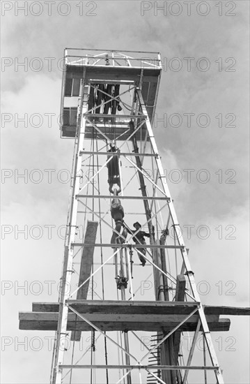 Low angle view of oil worker on oil derrick, Kilgore, Texas, USA, Russell Lee, U.S. Farm Security Administration