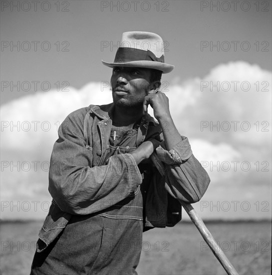 Agricultural worker resting while hoeing cotton on Allen Plantation, operated by Natchitoches farmstead association, a cooperative established through the cooperation of FSA (Farm Security Administration), Natchitoches, Louisiana, USA, Marjory Collins, U.S. Office of War Information, May 1940