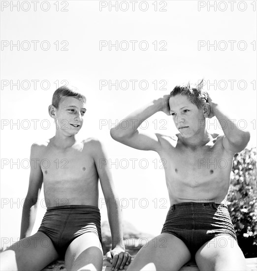 Two young teen boys in swimsuits relaxing after a swim, Rupert, Idaho, USA, Russell Lee, U.S. Farm Security Administration, July 1942