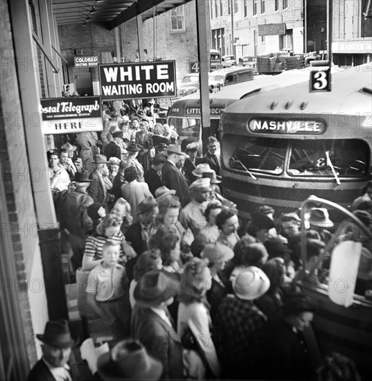 Crowded bus terminal with "White Waiting Room" sign in foreground and "Colored Waiting Room" in background, Memphis, Tennessee, USA, Esther Bubley, U.S. Office of War Information, September 1943