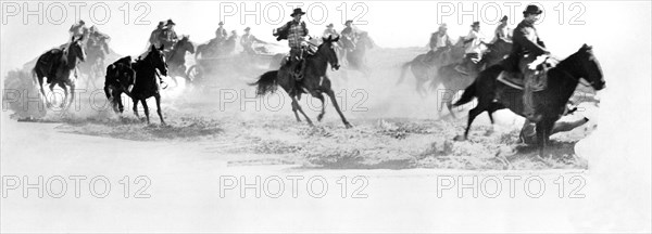 Cowboys on horseback during chase scene, on-set of the film, "Cheyenne", Warner Bros., 1947