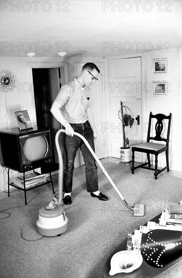 Charles Cline, married student at University of Illinois, vacuuming his apartment, Champaign, Illinois, USA, Warren K. Leffler, U.S. News & World Report Magazine Photograph Collection, April 1960