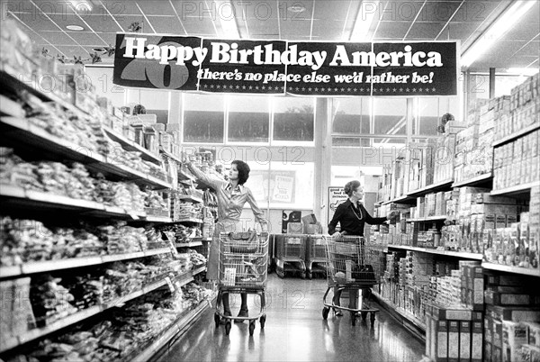 Two women shopping in grocery store under banner reading: "Happy birthday America, there's no place else we'd rather be!" commemorating the United States Bicentennial, Marion S. Trikosko, U.S. News & World Report Magazine Photograph Collection, May 1976