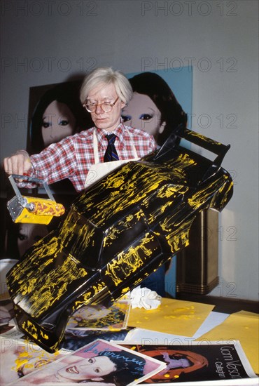 American pop artist Andy Warhol, half-length portrait painting miniature model car, Bernard Gotfryd, 1977