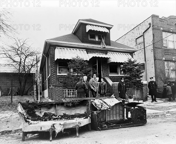 Exterior view of the home of Malcolm X after it was firebombed, remains of charred furniture in foreground, 23-11 97th Street,, East Elmhurst, Queens, New York City, New York, USA, Stanley Wolfson, New York World-Telegram and the Sun Newspaper Photograph Collection, February 14, 1965