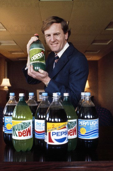 John Sculley, President of PepsiCo, Inc.,  half-length portrait with new 2-liter plastic bottles of Pepsi's various soft drinks, Bernard Gotfryd, 1979